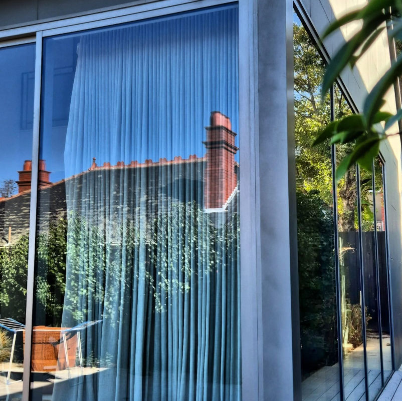 Spotless floor-to-ceiling windows reflecting garden